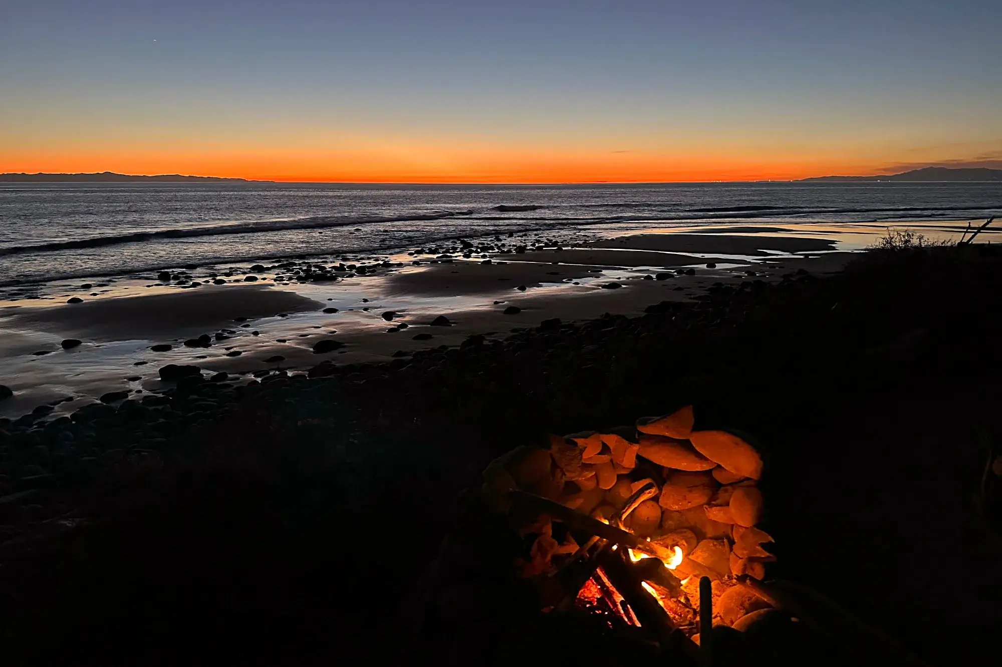 Sonnenuntergang am Emma Wood State Beach mit Blick auf den Pazifik, im Vordergrund ein Lagerfeuer